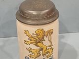a beer mug with a lion on it sitting on a table