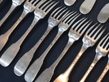 a lot of forks and spoons that are on a table