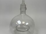 une carafe en verre transparent munie d'un bouchon en métal, sur fond blanc