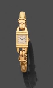 une image représentant une montre-bracelet dorée posée sur une surface noire