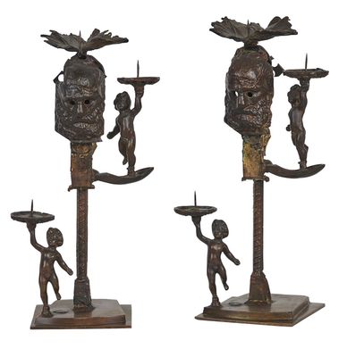 trois figurines en bronze représentant un homme et une femme portant un crâne sur la tête