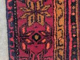 an image of a red and black rug on a white floor