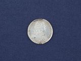 an old silver coin on a blue cloth