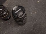 two camera lenses sitting on the ground next to each other