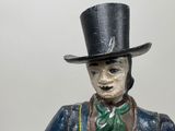 a statue of a man with a top hat and green tie