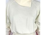 un gros plan sur un mannequin portant un pull blanc et un pantalon rouge