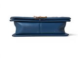 a blue leather clutch bag with a gold clasp