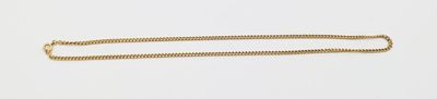 a long gold chain on a white surface