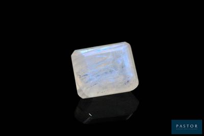 une pierre oplite blanche de forme carrée posée sur une surface noire