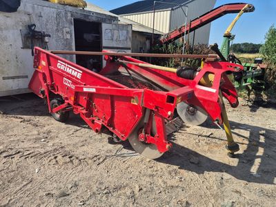 un tracteur rouge avec une remorque attelée à l'arrière