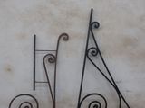 two wrought iron letters that are on the side of a building