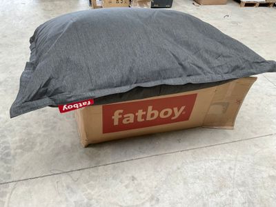 a box with a pillow on top of it on the floor