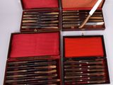 several knives and a knife sharper in a case on a white surface