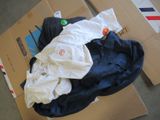 un tas de vêtements par terre, à côté d'un carton