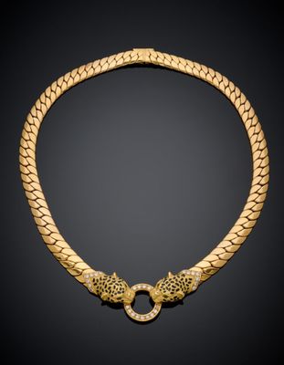 a gold necklace with two lions on a black background