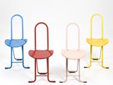 trois chaises de couleurs différentes placées côte à côte sur une surface blanche