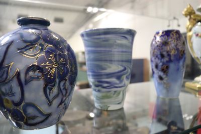 de nombreux vases posés sur une table en verre dans une pièce