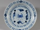 une assiette bleue et blanche sur laquelle est représenté un crabe