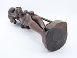an old wooden statue of a woman laying on a log