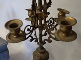 a brass candelab with three candles on top of it