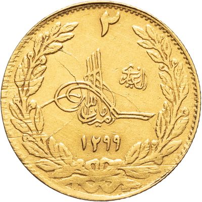 a close up of a gold coin with arabic writing on it