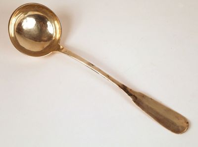 a gold spoon with a spoon handle on a white surface