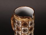 a brown and white cup that has a pattern on it