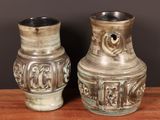 two vases that are sitting on a wooden table