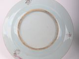 a blue plate with a gold rim sitting on a white surface