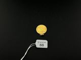 a close up of a gold coin with a price tag on it