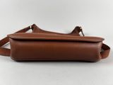 a brown leather bag with a strap on it