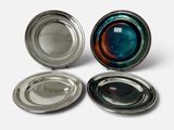 trois plats en verre argenté et bleu posés sur une surface blanche