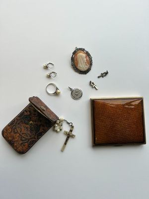 une petite boîte contenant une clé, une bague et d'autres objets, posée sur une surface blanche