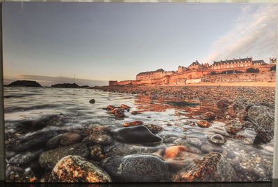 une image représentant une photo d'une plage avec des rochers au premier plan