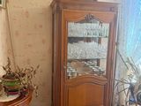 un meuble en bois placé dans un coin de la pièce, sur lequel se trouve une horloge