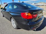 the rear end of a black bmw car parked in a parking lot