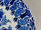 a blue and white plate with a bird and flowers on it