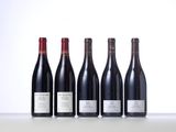 four bottles of wine are lined up on a table