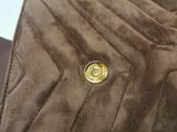 a brown jacket with a gold button on it