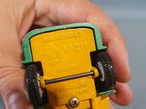 a person holding a yellow toy truck in their hand