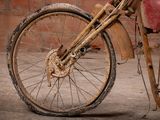 a dirty bike parked in front of a brick wall