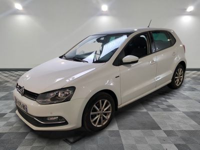 La Volkswagen Polo blanche est garée dans une grande pièce au sol carrelé.