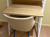 un bureau avec une chaise devant, dans une pièce