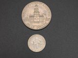 two coins sitting next to each other on a black surface