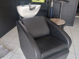 une chaise noire et un lavabo blanc dans une pièce