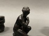 three figurines of a man sitting on a table