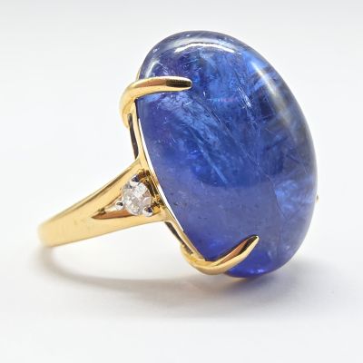 une bague en or jaune sertie d'une tanzanite ovale et de diamants