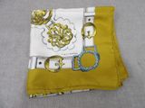 yellow and white pocket square with gold monograms and a gold buckle