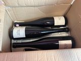 three bottles of wine in a box on the table