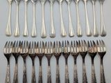 six forks and six spoons are lined up on a table
